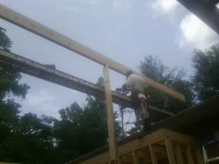 Carpenter setting a ridge beam over a new addition frame — Ice Dam Removal by Roofing Brothers in Kimmswick