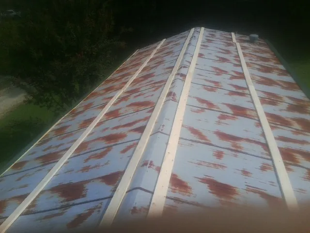 Rusted metal roof panels with new wood purlins before replacement — Storm Damage Roof Repair in Kimmswick by Roofing Brothers