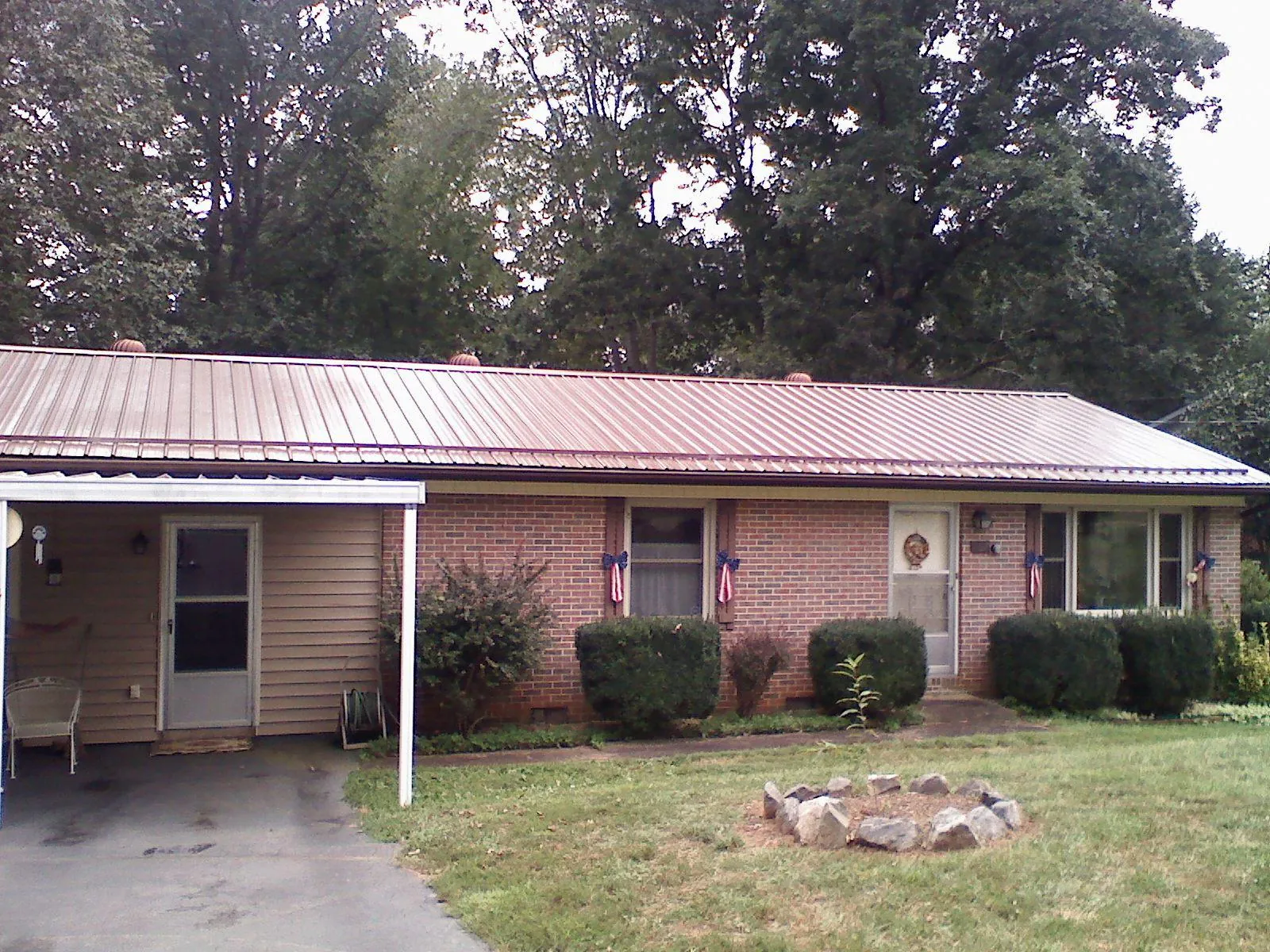 Bronze metal roof and carport on a brick ranch home — Roof Repair work by our crew in Kimmswick